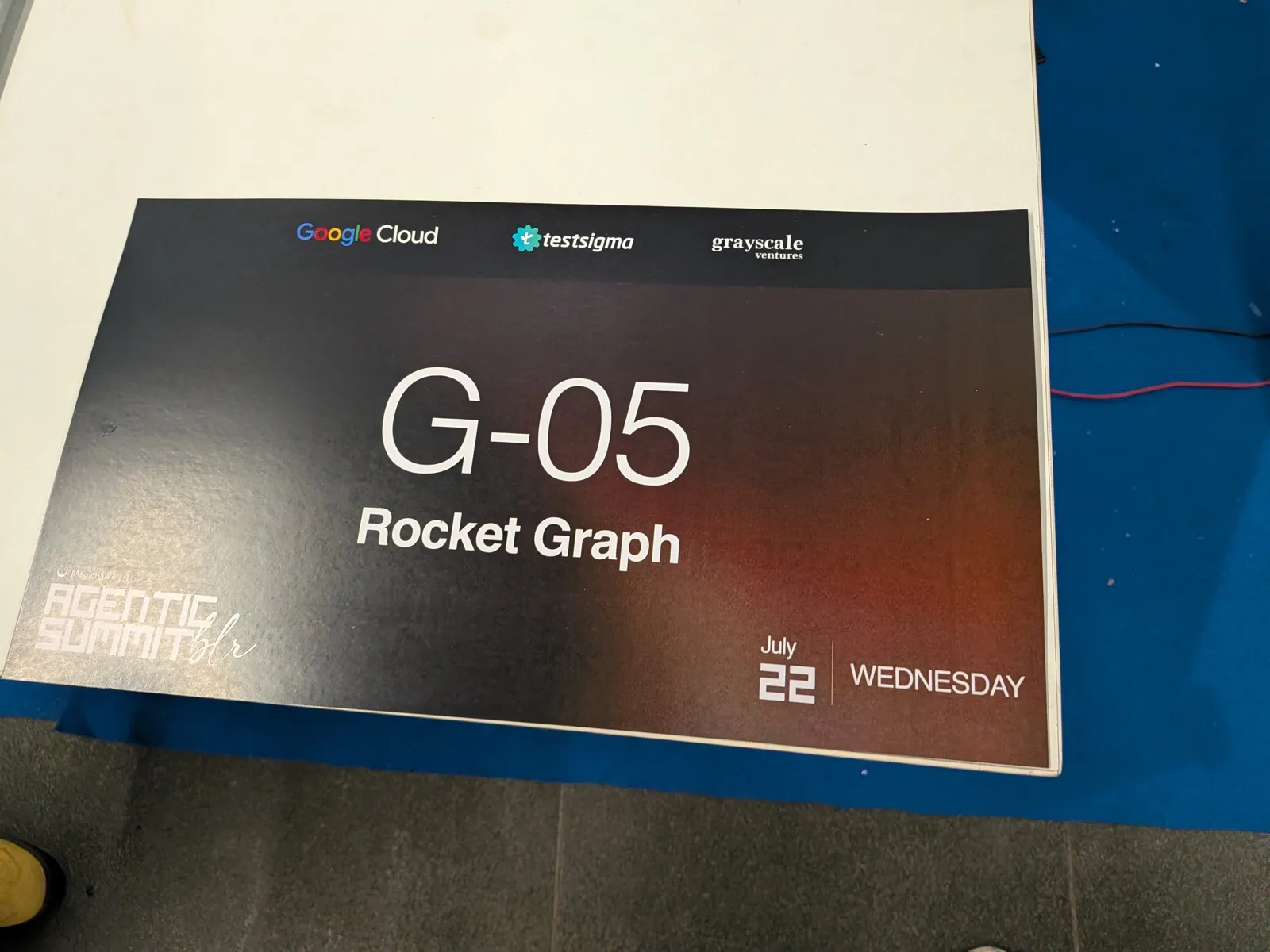 A booth placard reading G-05 Rocket Graph, with Google Cloud, Testsigma and Grayscale Ventures logos