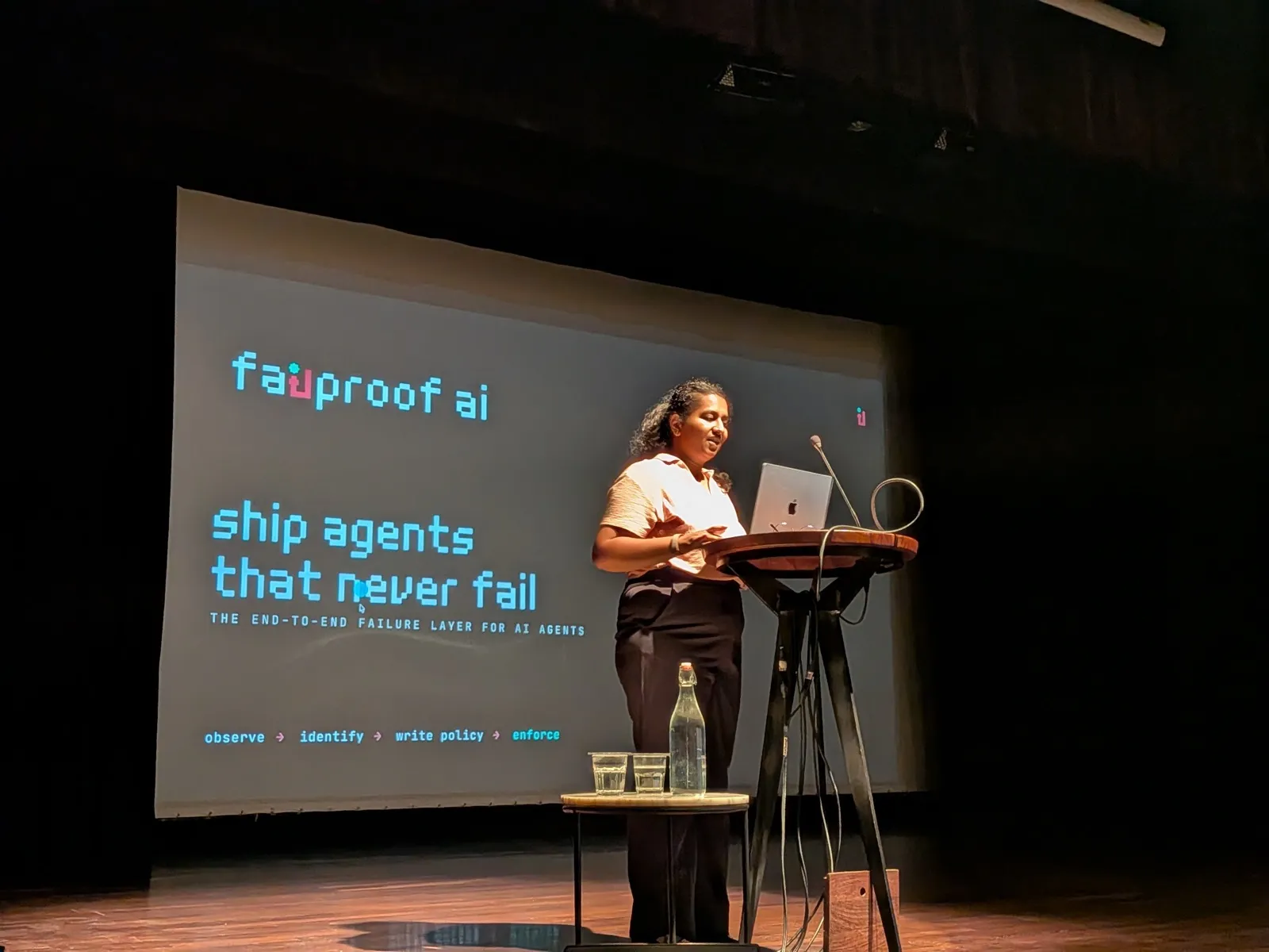 Failproof AI presenting on stage — slide reads “ship agents that never fail: the end-to-end failure layer for AI agents”
